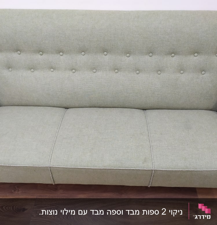 ספה ירוקה עם כפתורים על משענת הגב